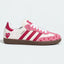 Pink and white heart-pattern low-top sneakers with gum soles.