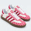Pink and white heart-pattern low-top sneakers with gum soles.