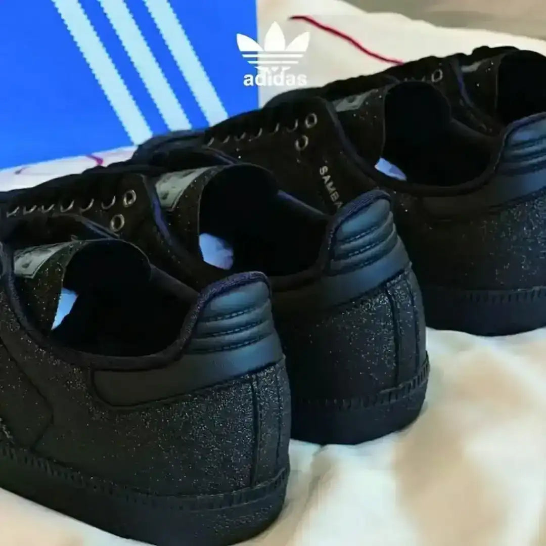 Adidas Samba black leather sneakers featuring a subtle glitter texture, black laces, silver tongue label and a dark gum sole for a bold lifestyle look.