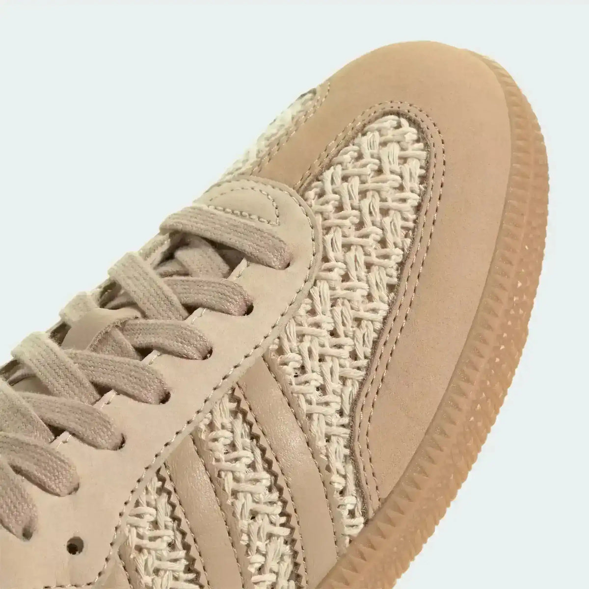Close-up of beige laces and the woven toe panel.