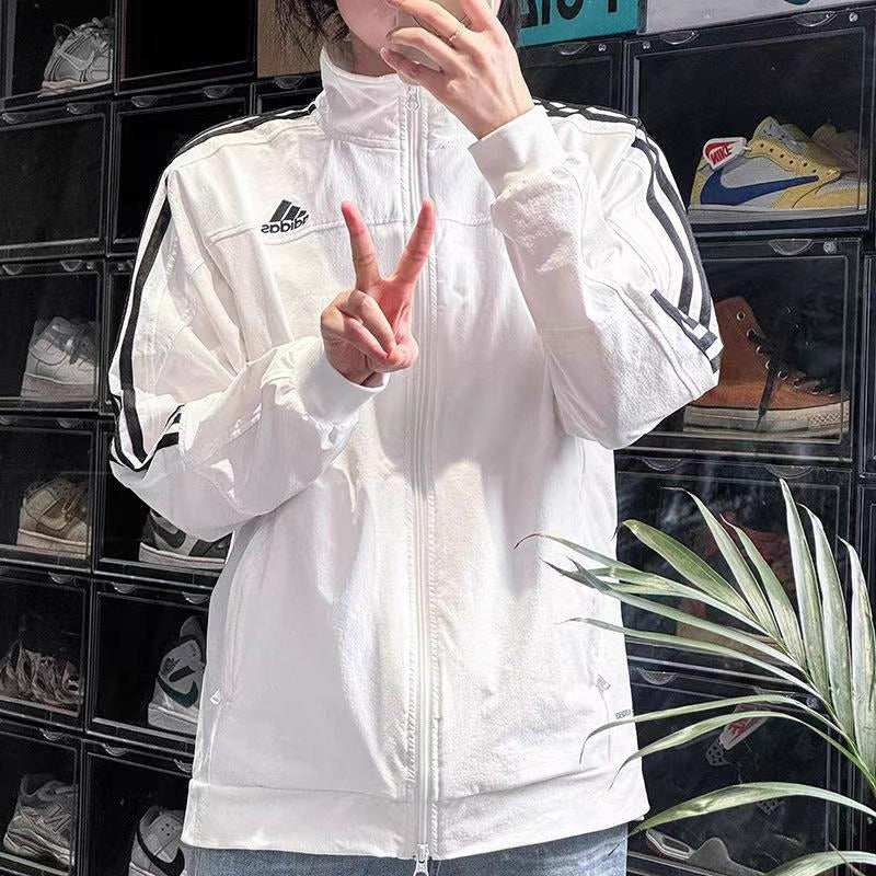 Close up of Adidas WIND.RDY jacket fabric texture and durable zipper pockets.