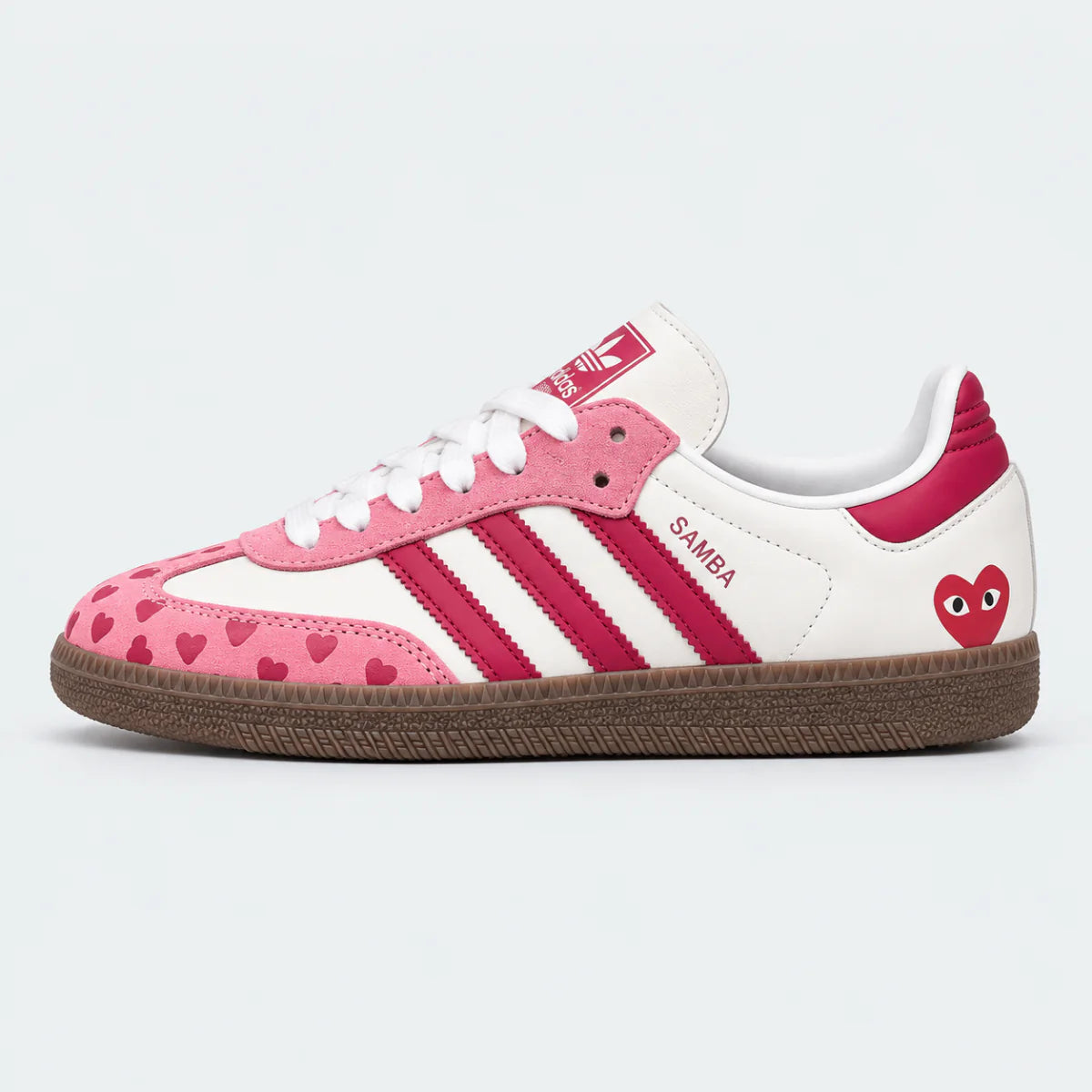 Pink and white heart-pattern low-top sneakers with gum soles.