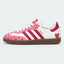 Pink and white heart-pattern low-top sneakers with gum soles.