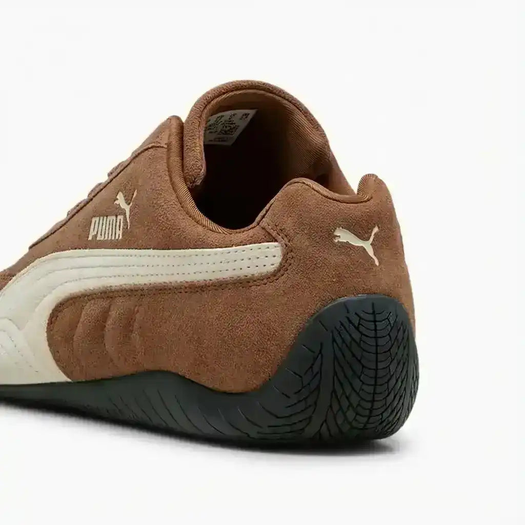Brown low-profile lace-up sneakers with cream curved side stripes.