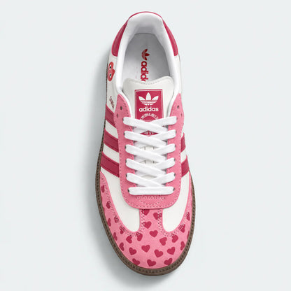 Pink heart-pattern sneaker with white laces, top view.