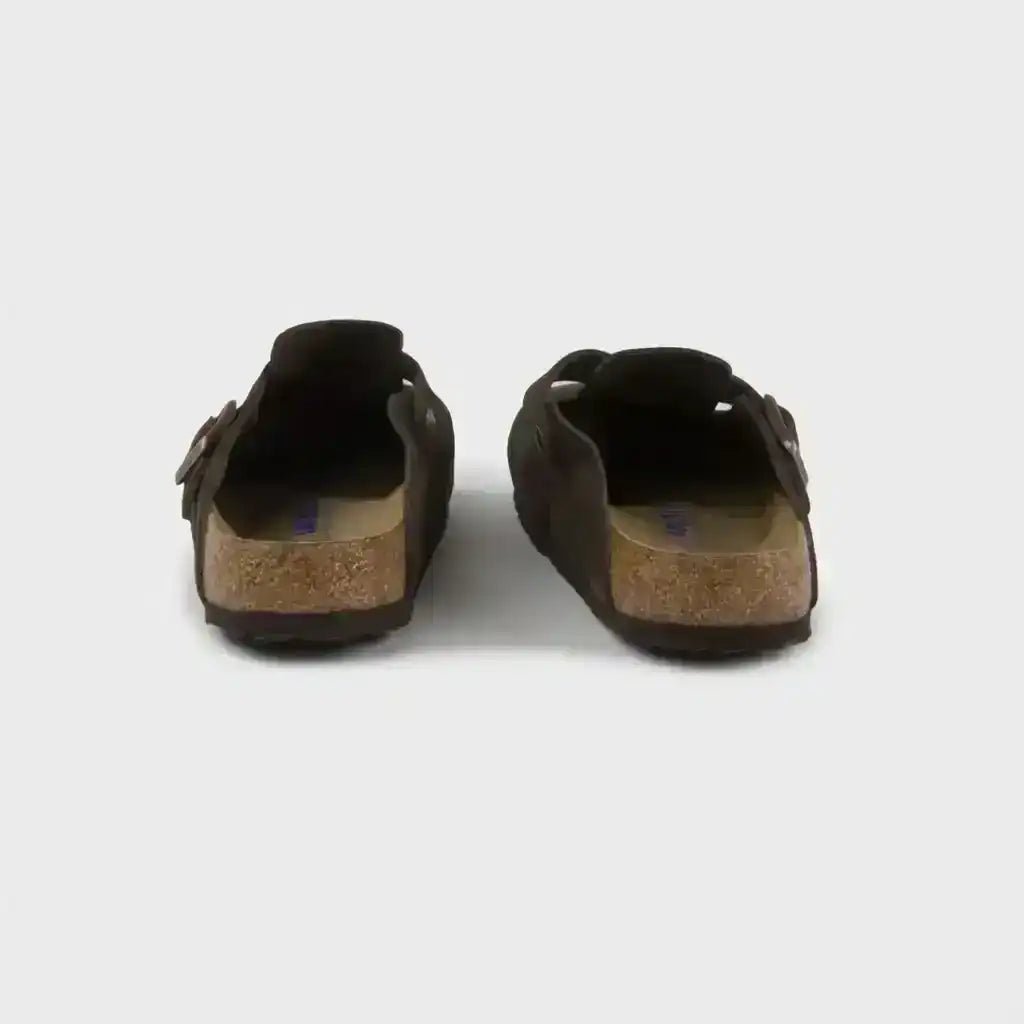 Dark brown closed-toe clogs with buckle straps.