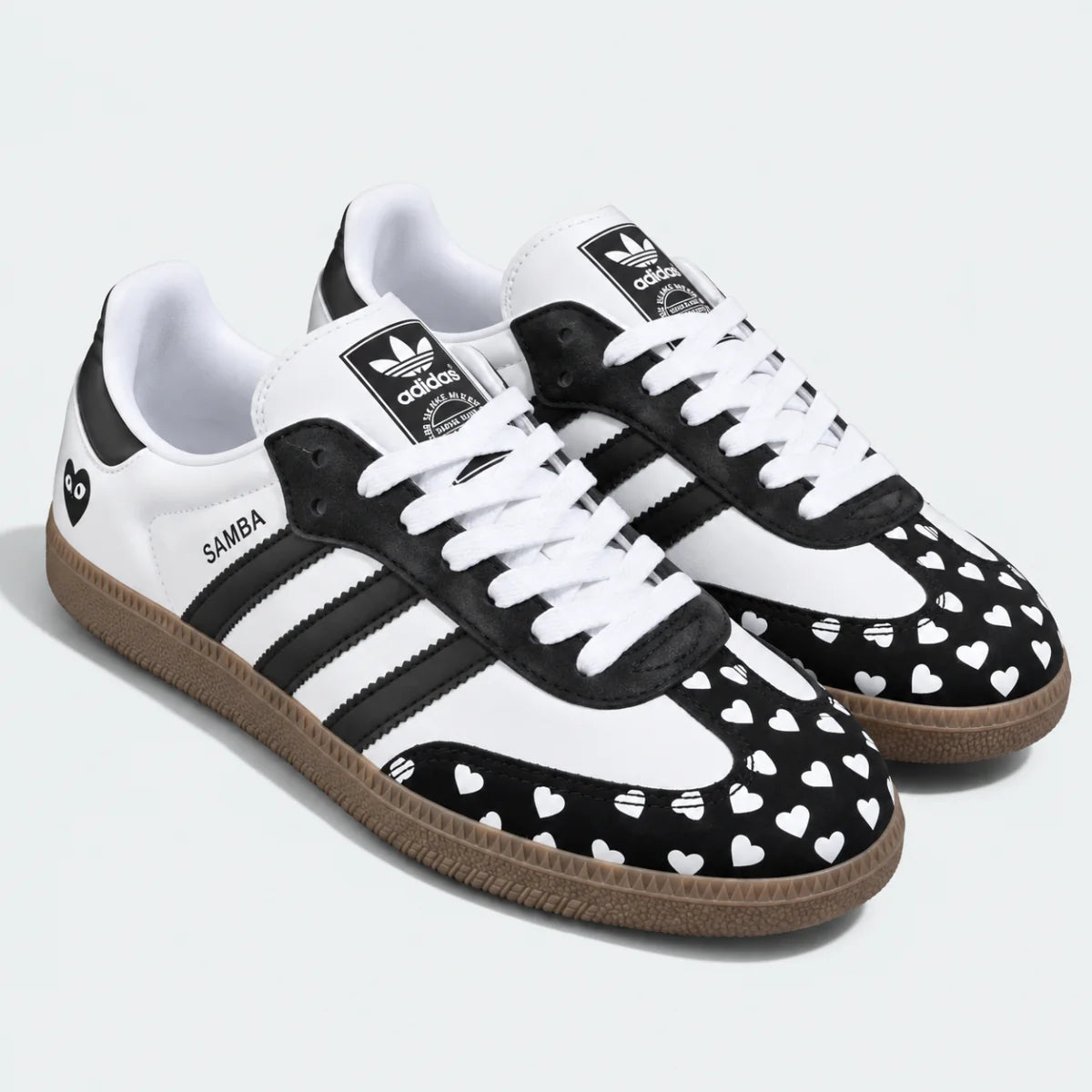 Black and white heart-pattern low-top sneakers, pair view.