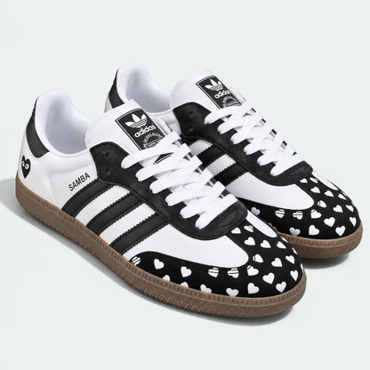 Black and white heart-pattern low-top sneakers, pair view.