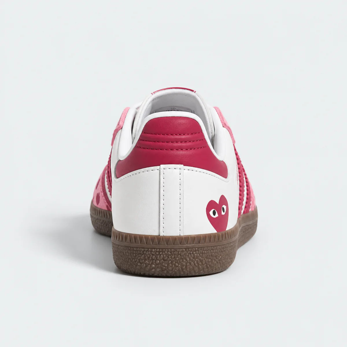 Pink and white heart-pattern low-top sneakers with gum soles.