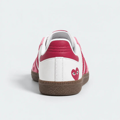 Pink and white heart-pattern low-top sneakers with gum soles.