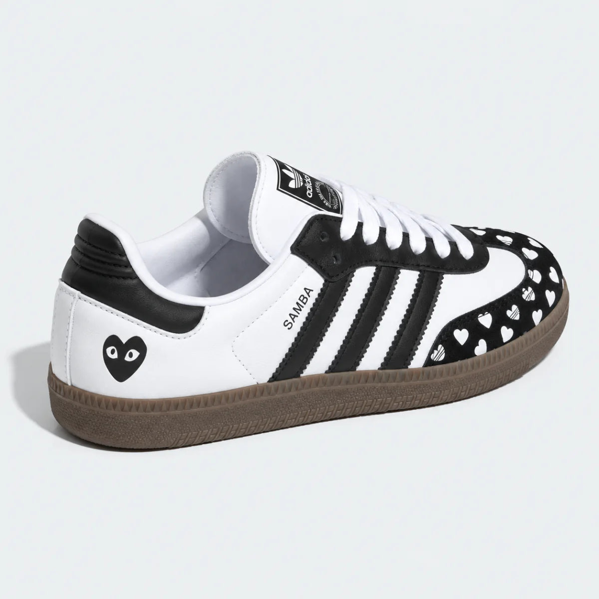 Black and white heart-pattern low-top sneaker, side view.