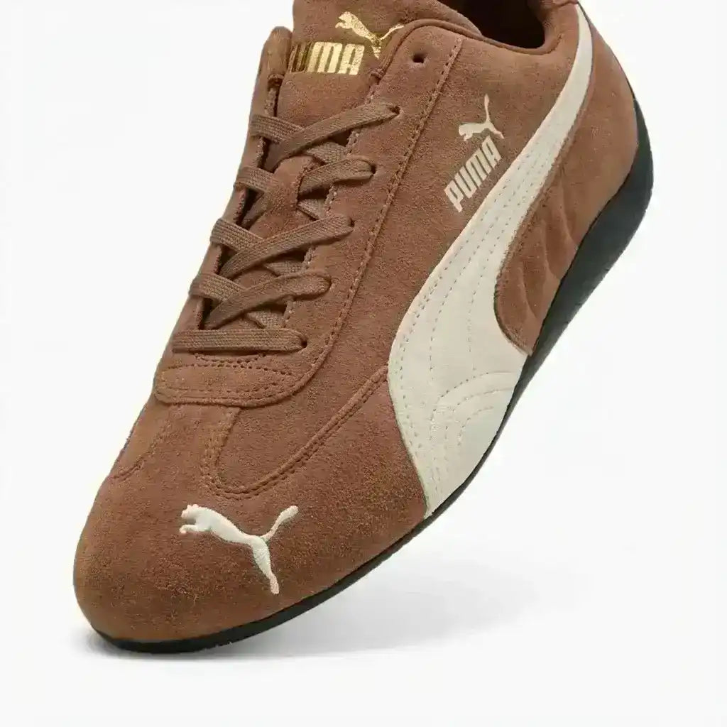Brown low-profile lace-up sneakers with cream curved side stripes.