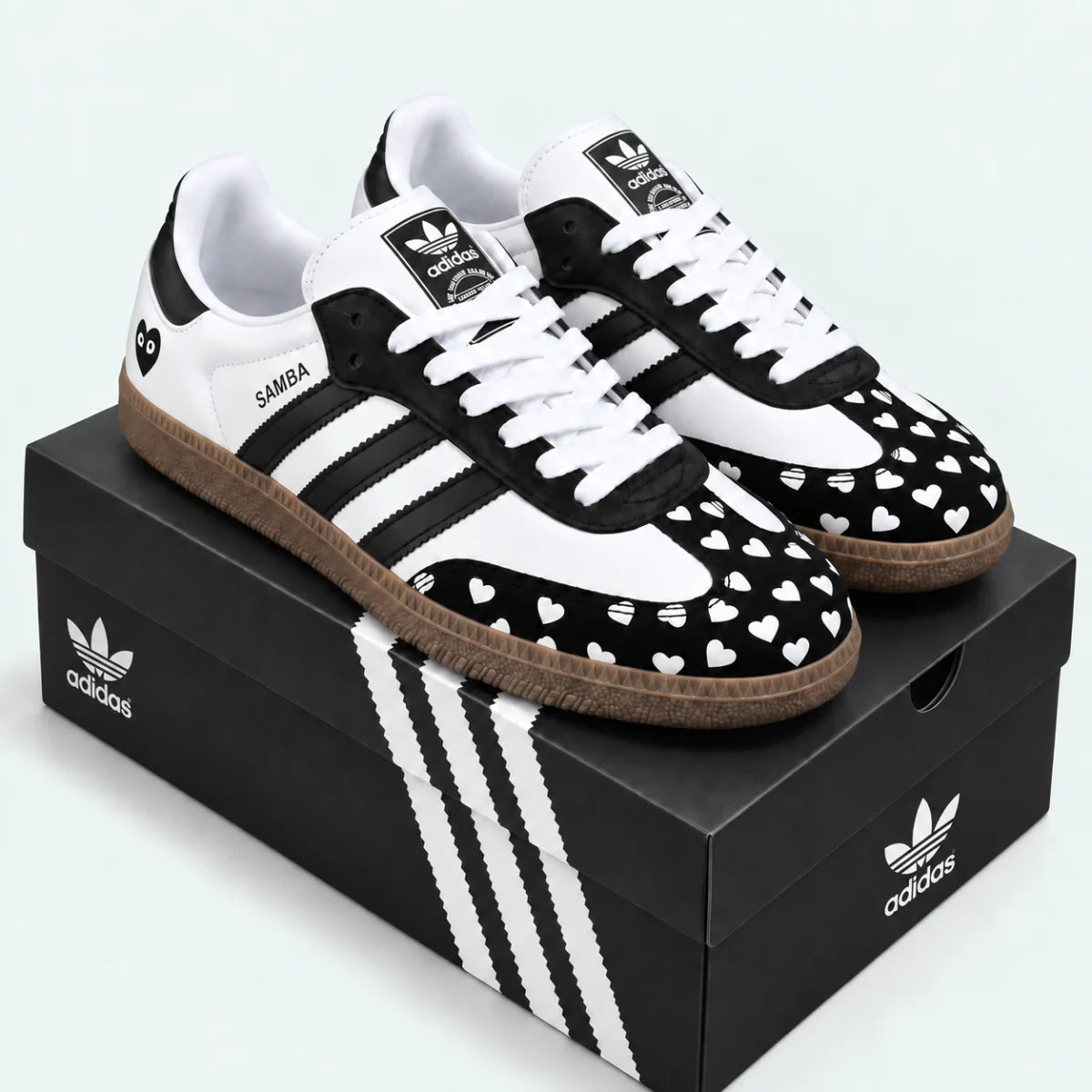 Black and white heart-pattern sneakers displayed on a shoe box.