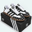 Black and white heart-pattern sneakers displayed on a shoe box.