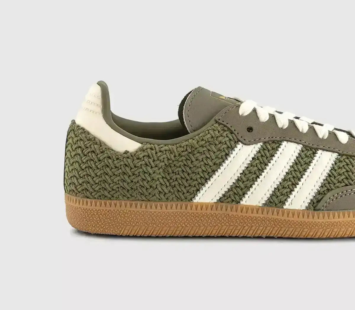 Olive green woven-texture sneakers with cream stripes and gum soles.