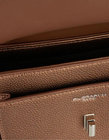 Close-up of a brown handbag's textured surface, zipper and hardware.