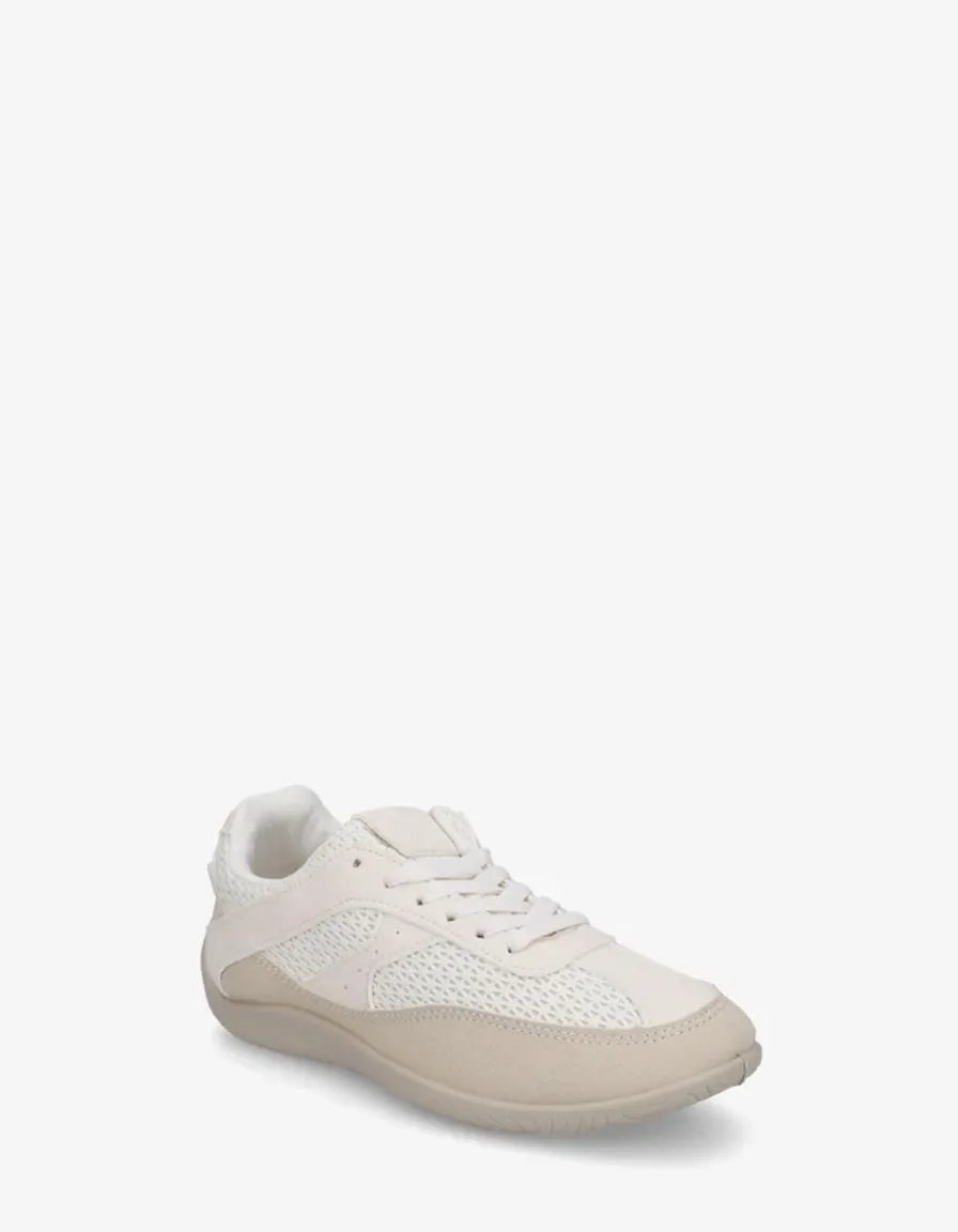 Off-white low-top lace-up sneakers with pale textured soles.