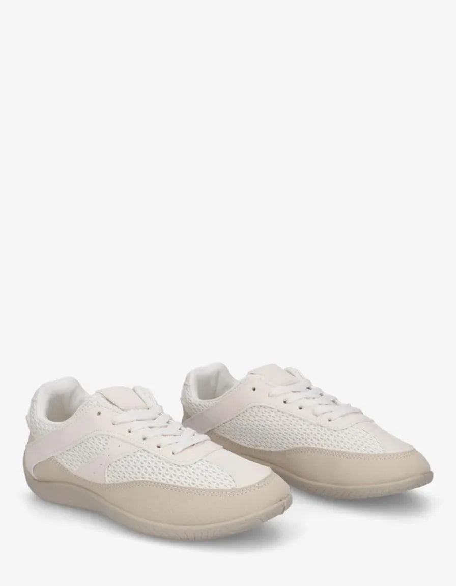 Off-white low-top lace-up sneakers with pale textured soles.