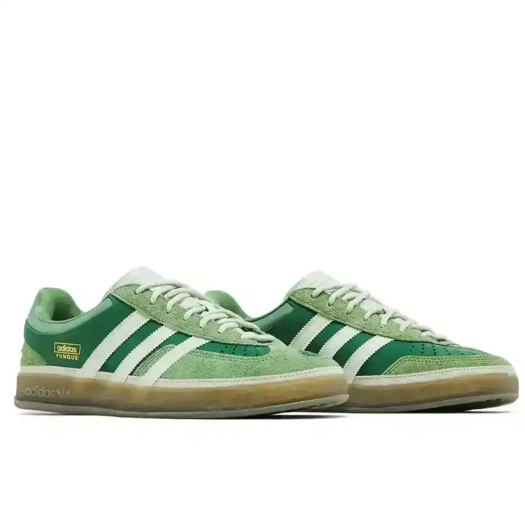 Green three-stripe low-top sneakers with gum soles.