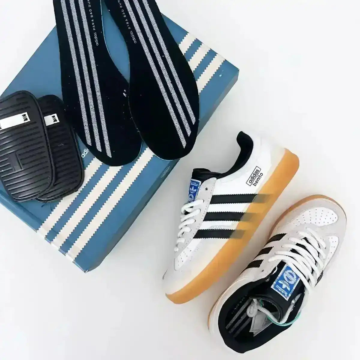 Cream and black three-stripe sneakers with gum soles.