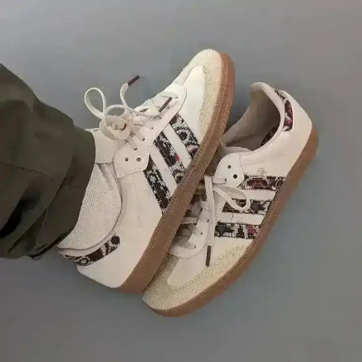 Cream low-top sneakers with multicolored patterned panels.