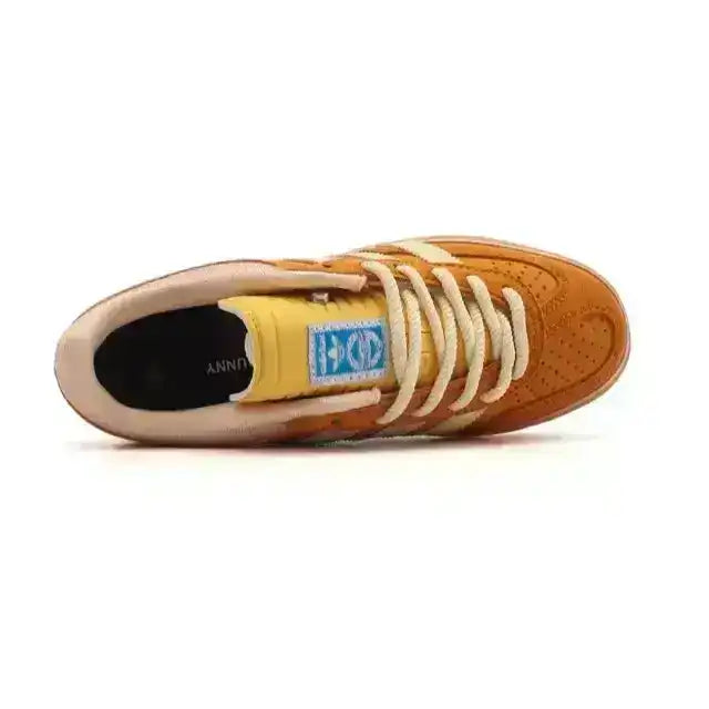 Orange and cream three-stripe low-top sneakers with gum soles.
