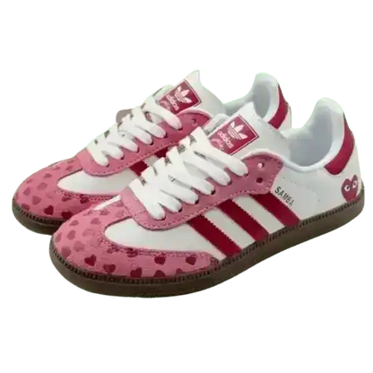 Pink and white low-top sneakers with small heart patterns.