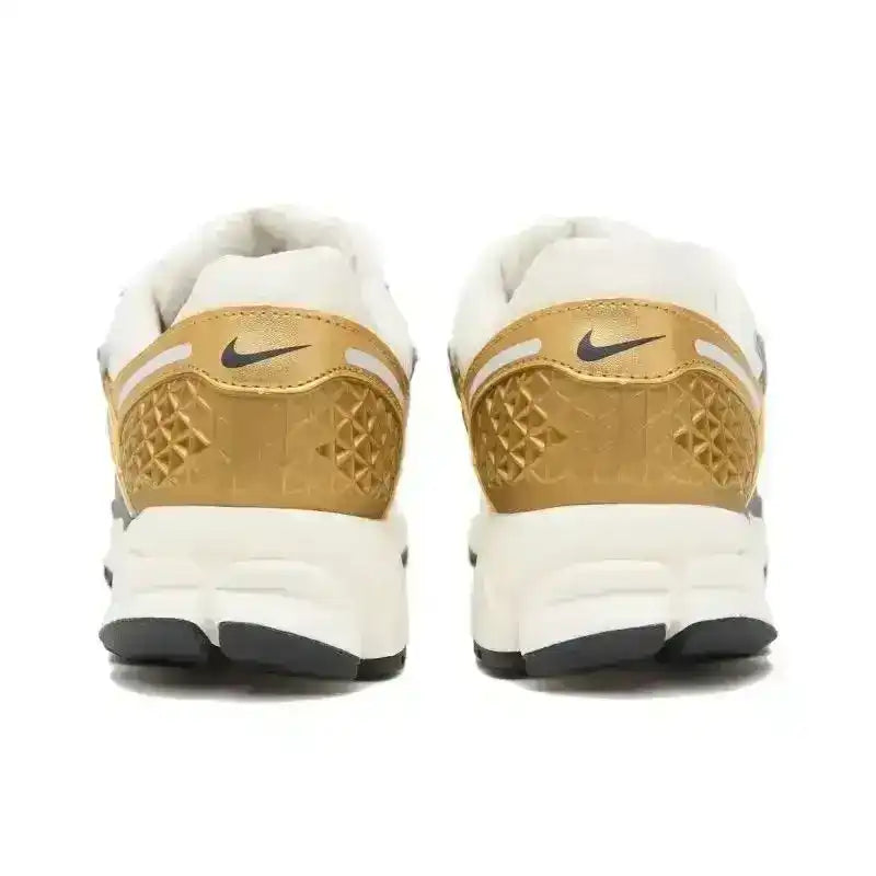 Gold-colored and cream sneakers with layered panels and chunky soles.