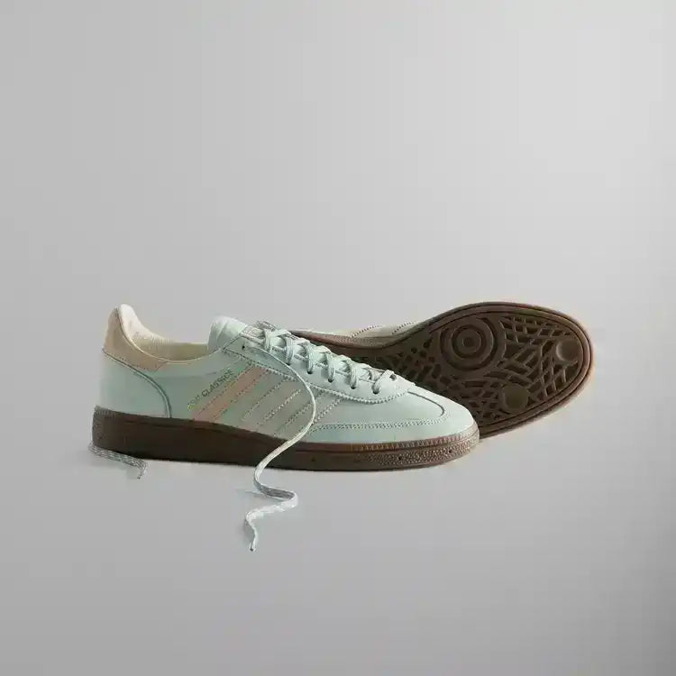 Pale mint low-top sneakers with cream stripes and brown soles.
