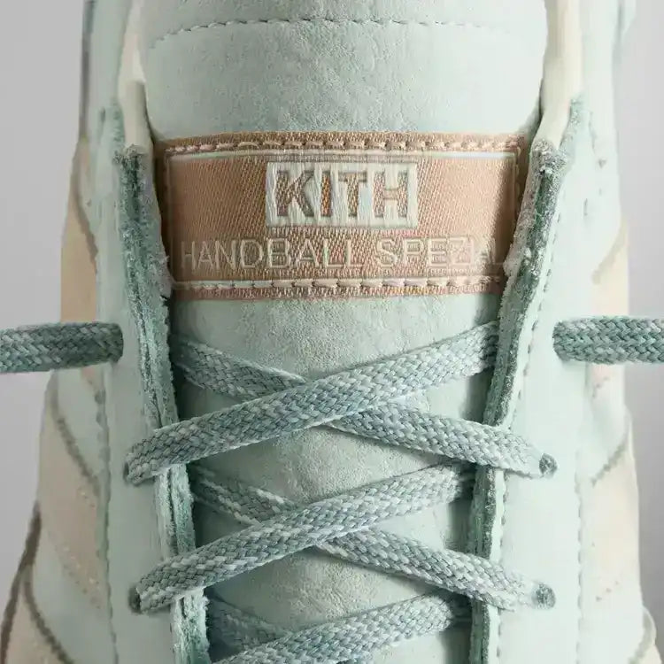 Close-up of mint sneaker laces and tongue label.