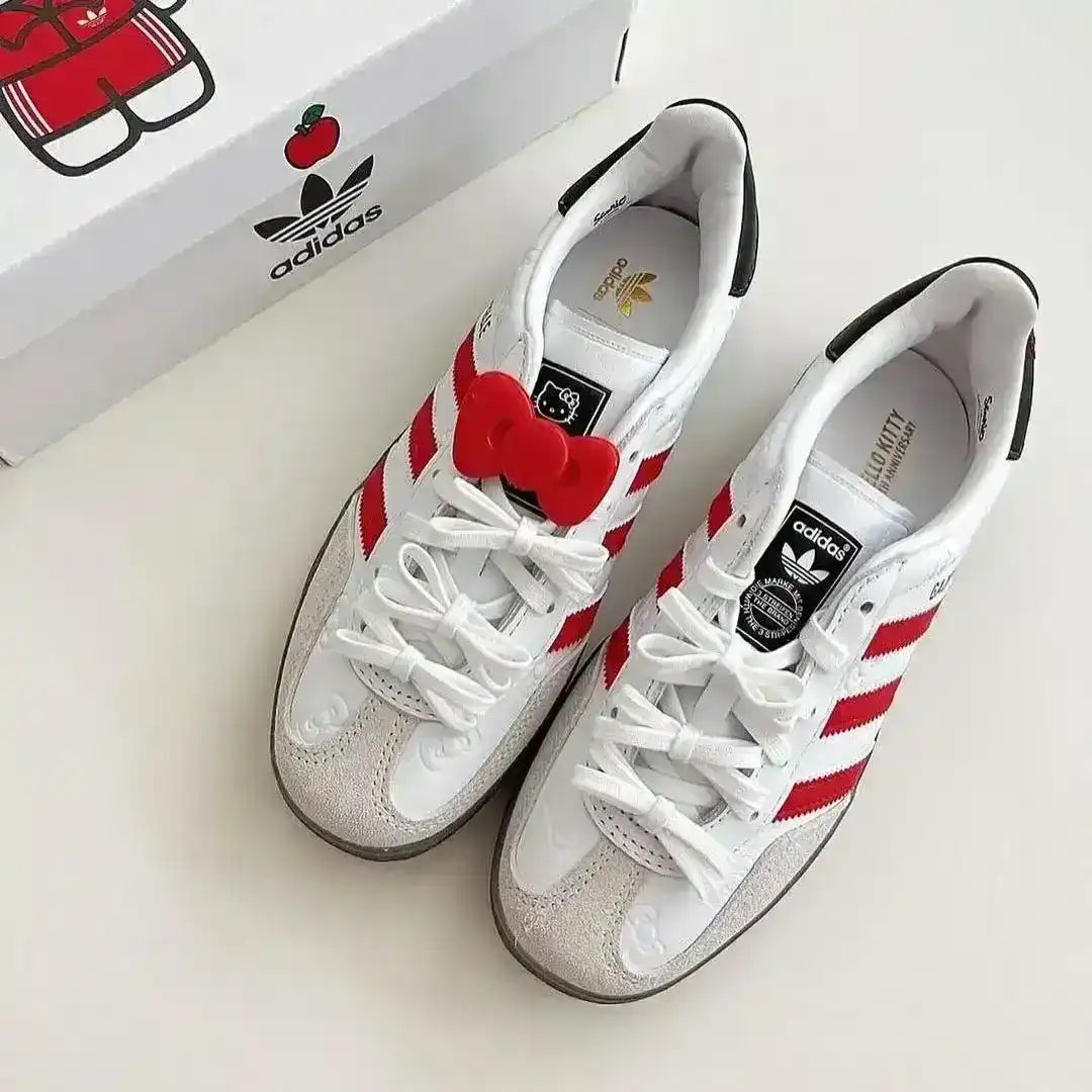 White Adidas Gazelle Indoor Hello Kitty edition with red stripes and bow, perfect for cute kawaii fashion outfits and sneaker collectors.
