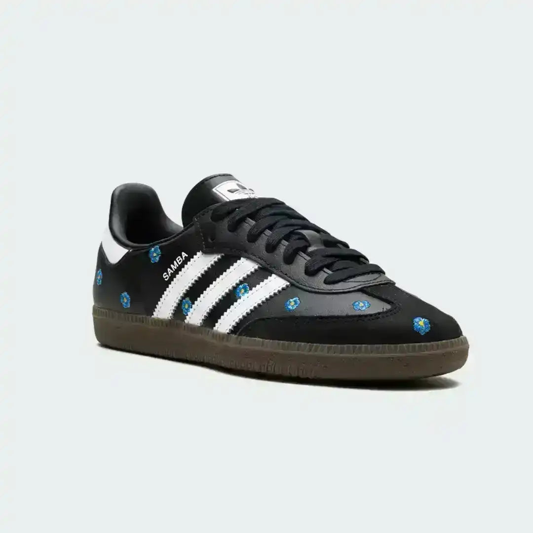 Adidas Samba floral edition in black leather with embroidered blue flowers, white stripe branding and a vintage gum sole for everyday comfort.
