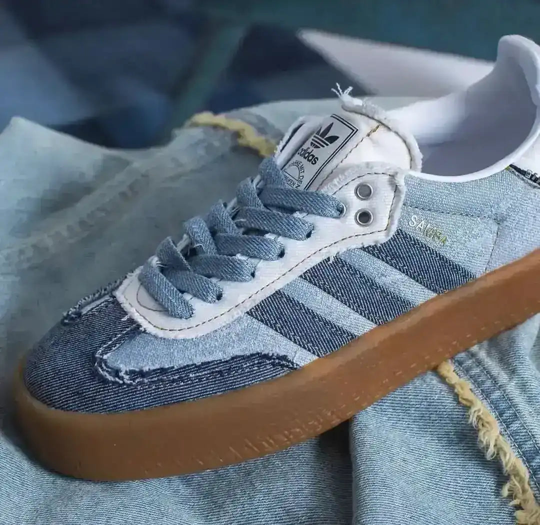 Blue denim-look low-top sneakers with pale laces and gum soles.