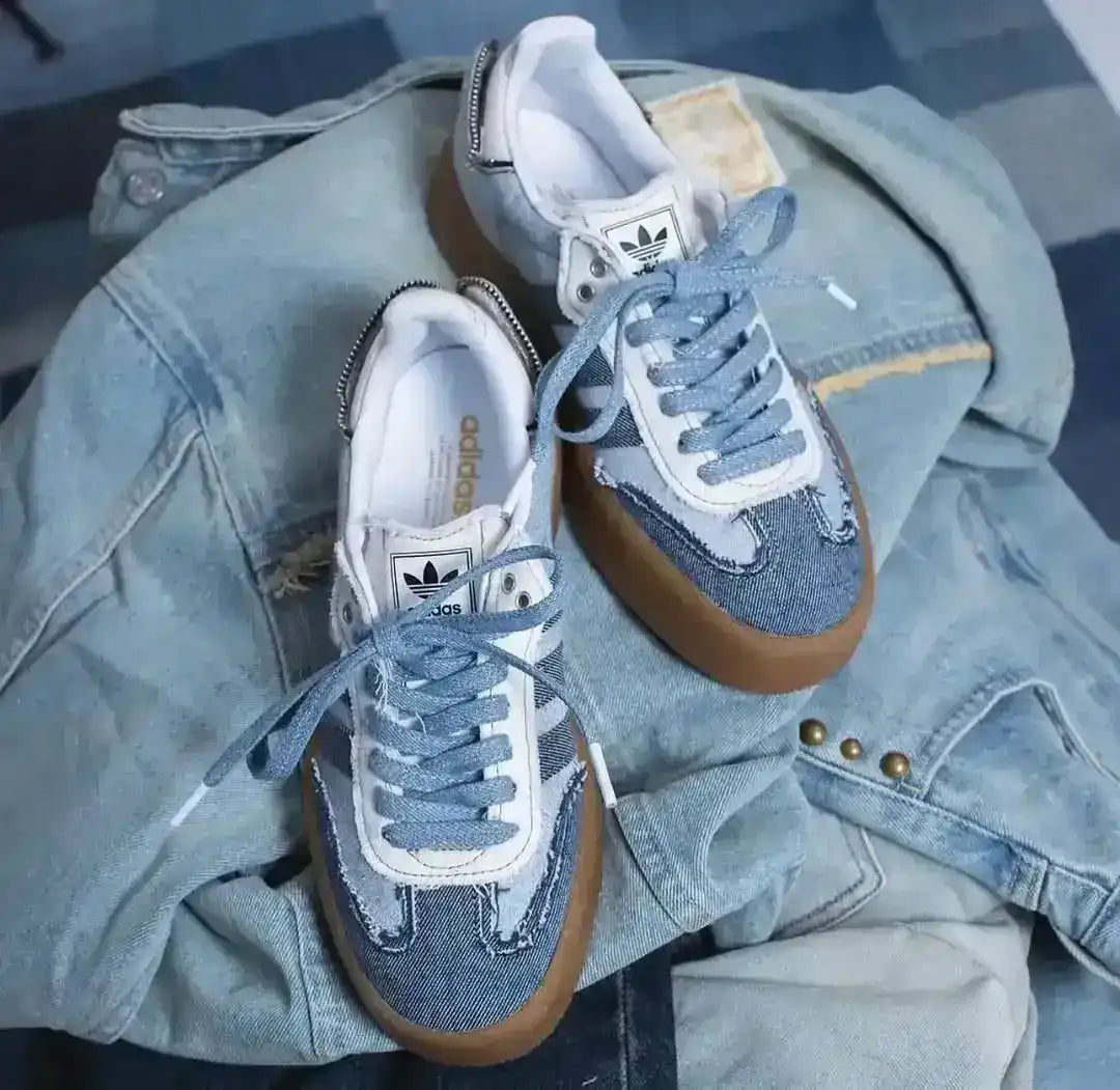 Blue denim-look low-top sneakers with pale laces and gum soles.