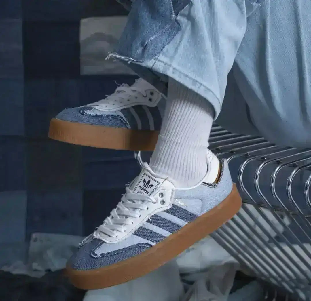 Blue denim-look low-top sneakers with pale laces and gum soles.