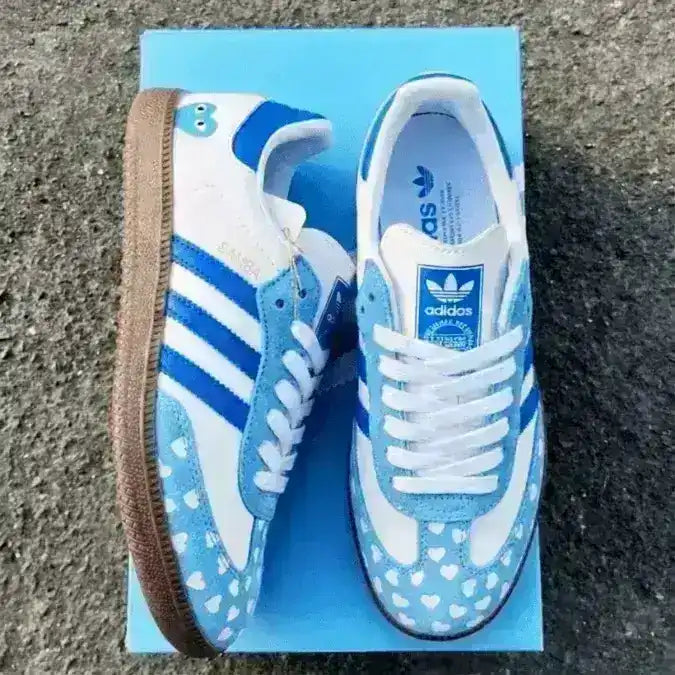 Unique Adidas Samba sneakers with a blue heart print on a white background, a special 2026 edition for a lovely and stylish look.