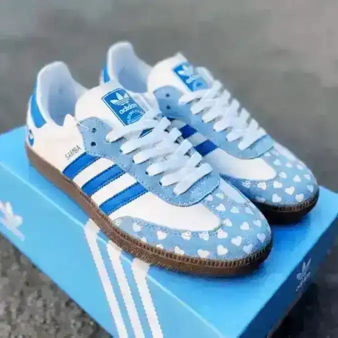 Playful Adidas Samba OG shoes in blue and white with an all-over heart pattern, offering a fun and lovely twist on a classic style.