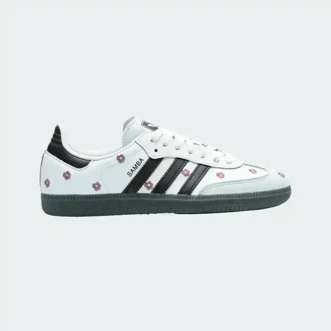 Adidas Samba white leather sneakers with embroidered pink flowers, black stripes and a dark gum sole blending classic design with a soft floral touch.