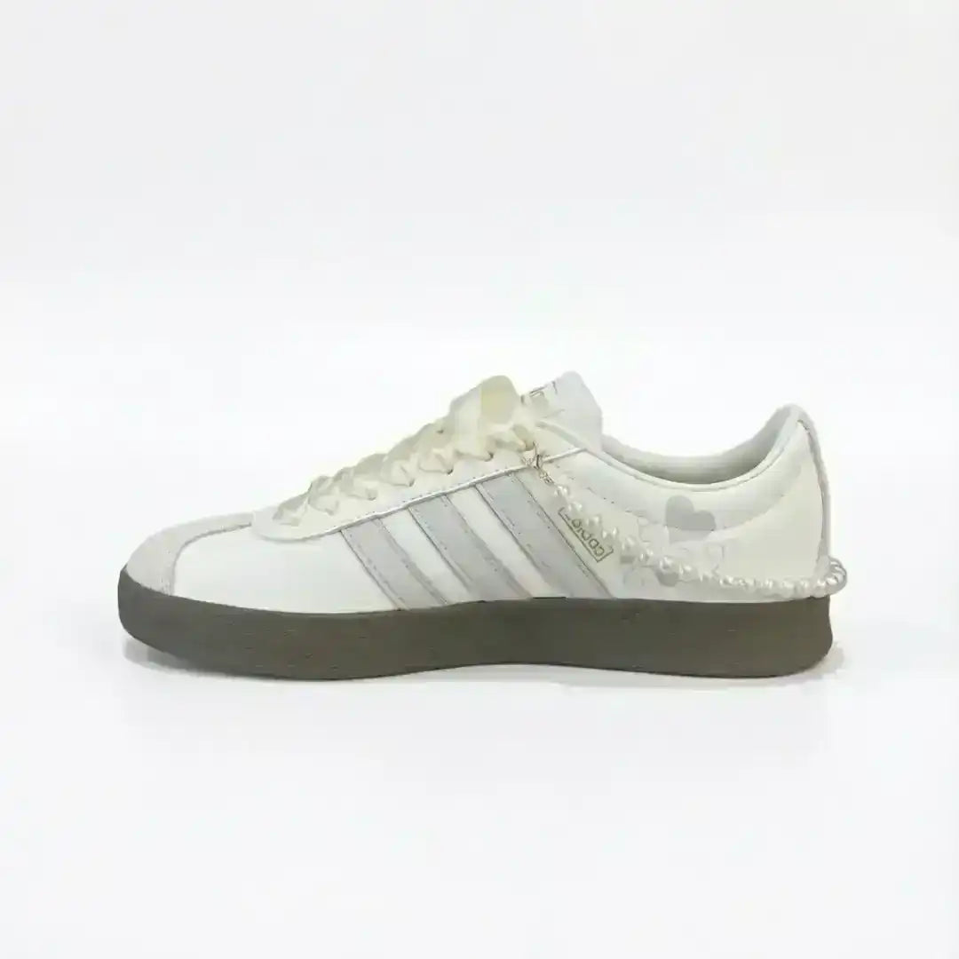 Adidas white and grey leather sneakers featuring a pearl ankle accessory, classic three-stripe design and a dark gum sole for a stylish lifestyle look.