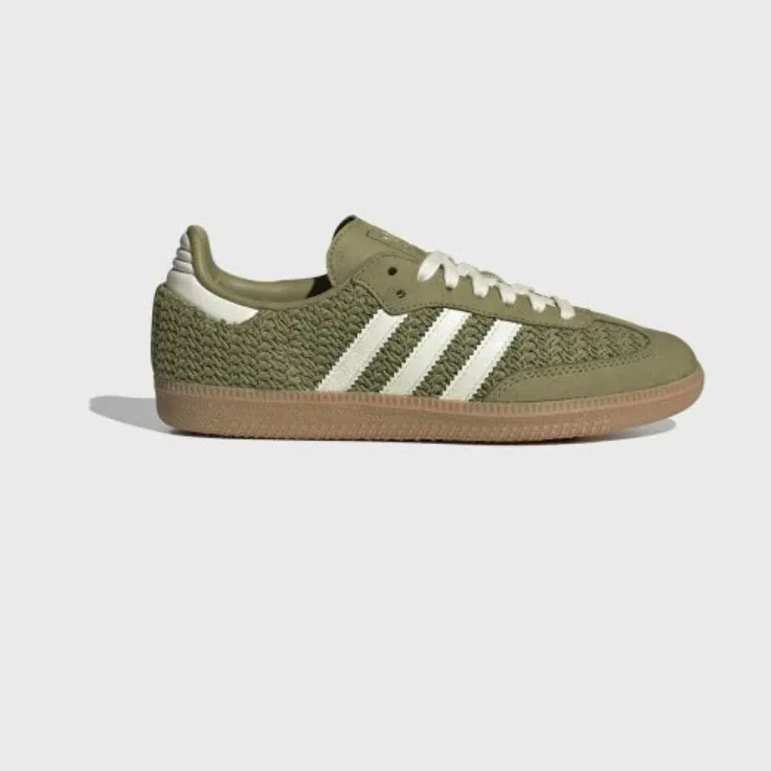 Olive green woven-texture low-top sneakers with cream stripes and gum soles.