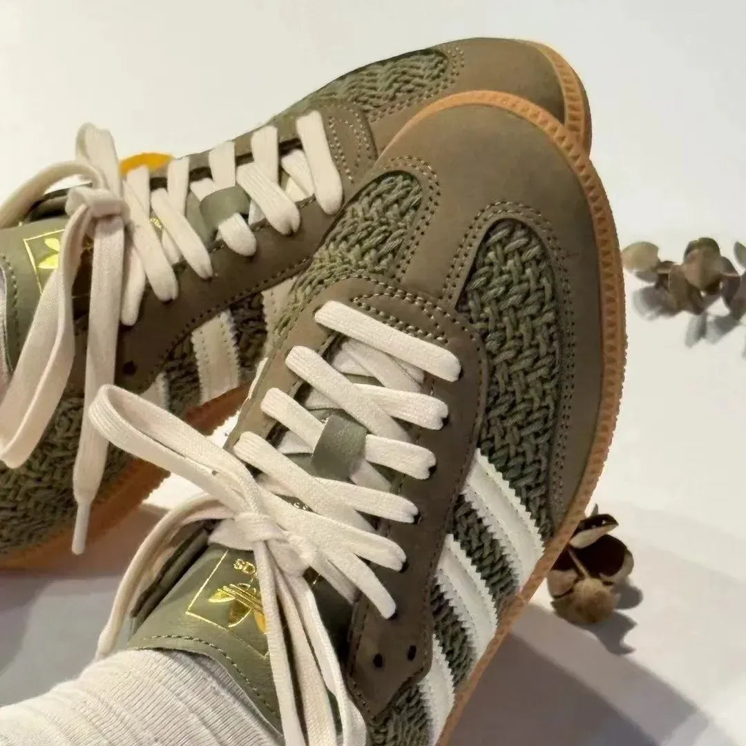 Olive green woven-texture low-top sneakers with cream stripes and gum soles.