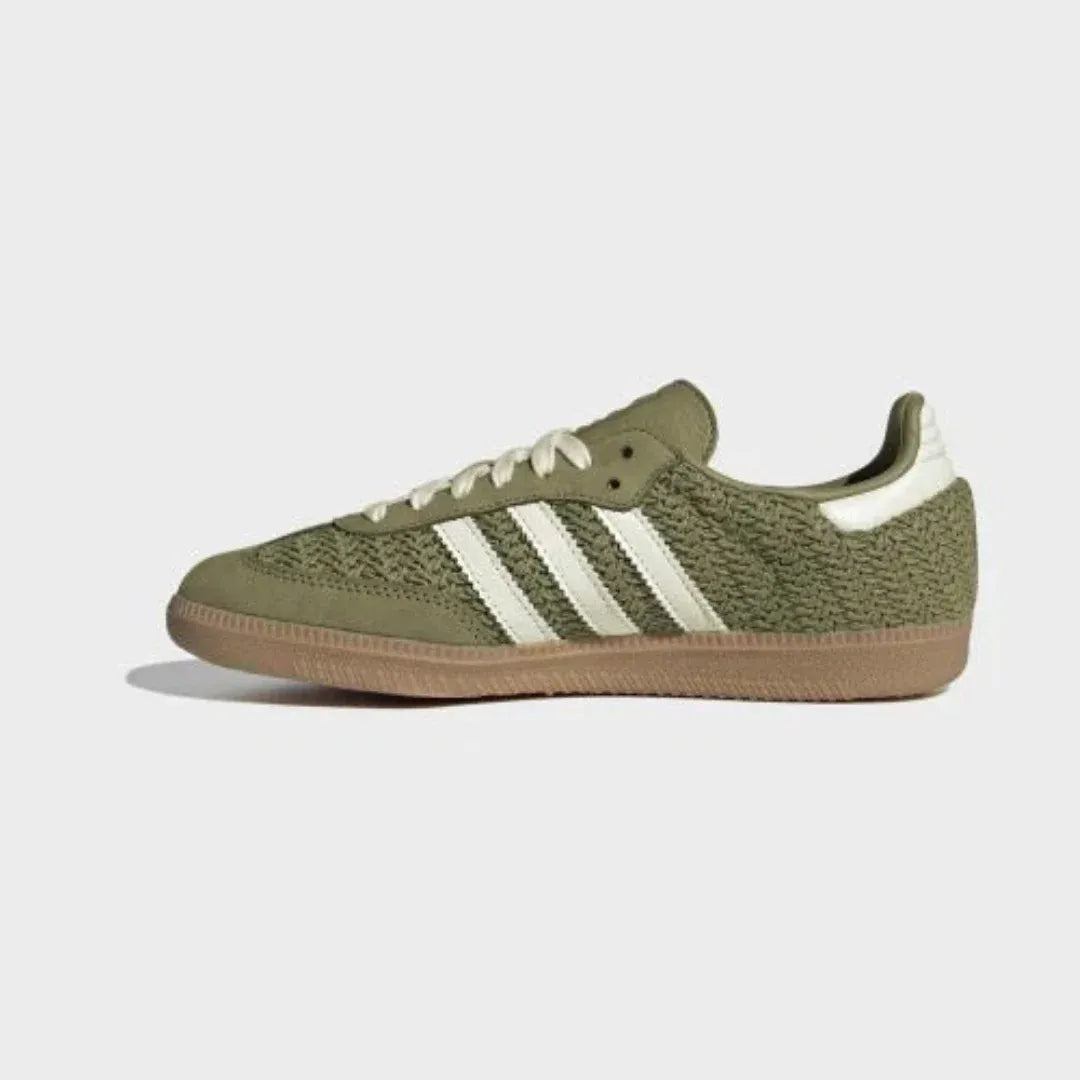 Olive green woven-texture low-top sneakers with cream stripes and gum soles.