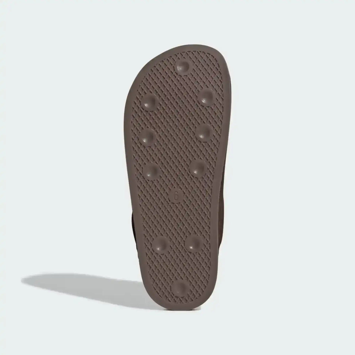 Brown slide-shoe outsole with small raised dots, bottom view.