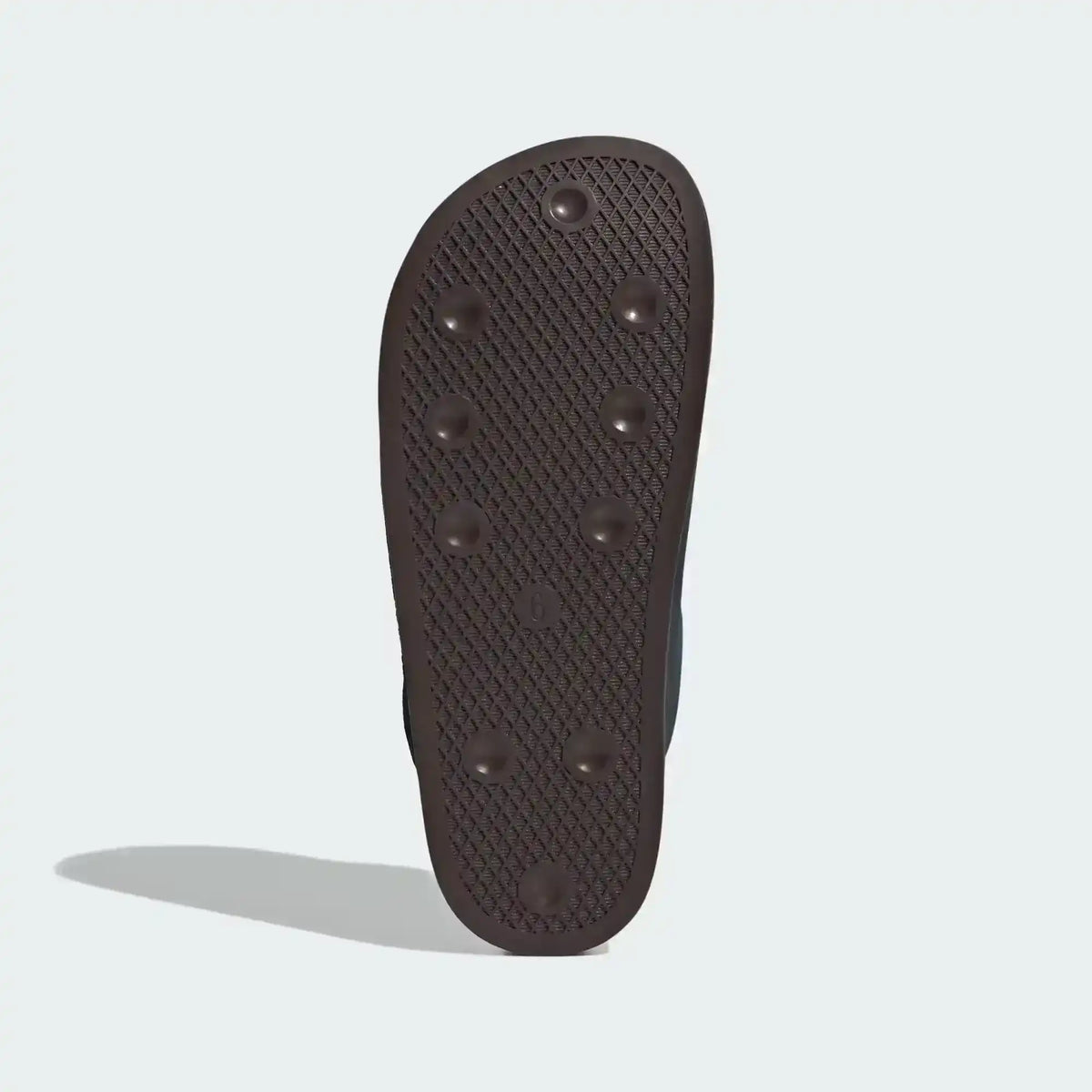 Dark slide-shoe outsole with small raised dots, bottom view.