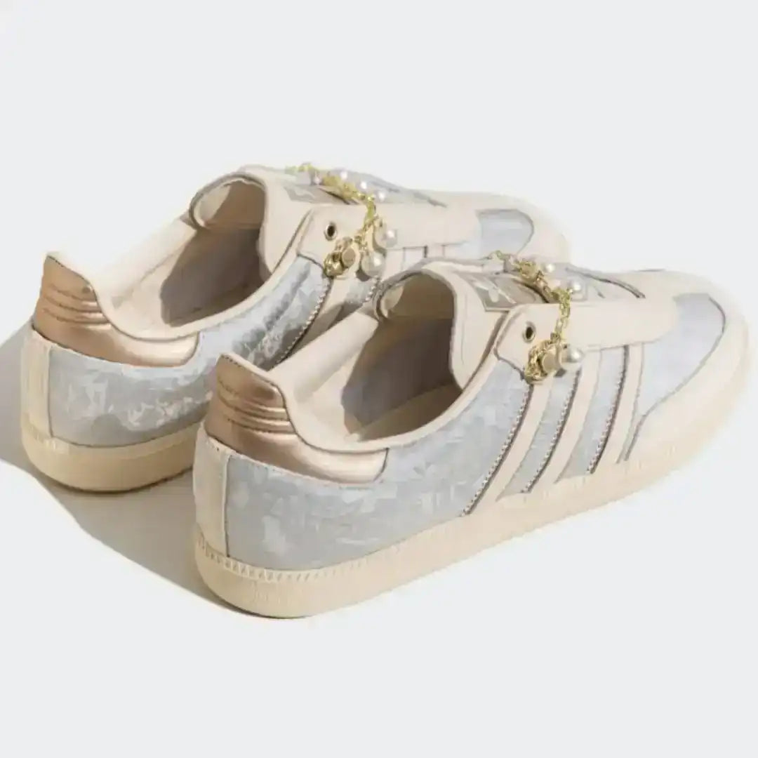 Adidas sneakers in beige featuring a pearl and gold chain accessory, textured material accents and a premium leather upper for stylish daily wear.