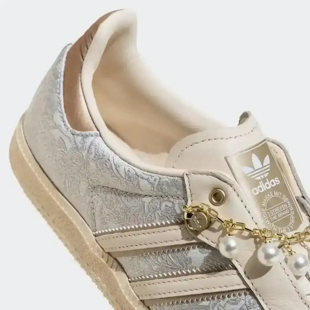 Beige Adidas lifestyle shoes with pearl chain details, textured side panels and a soft leather upper offering a refined modern fashion look.