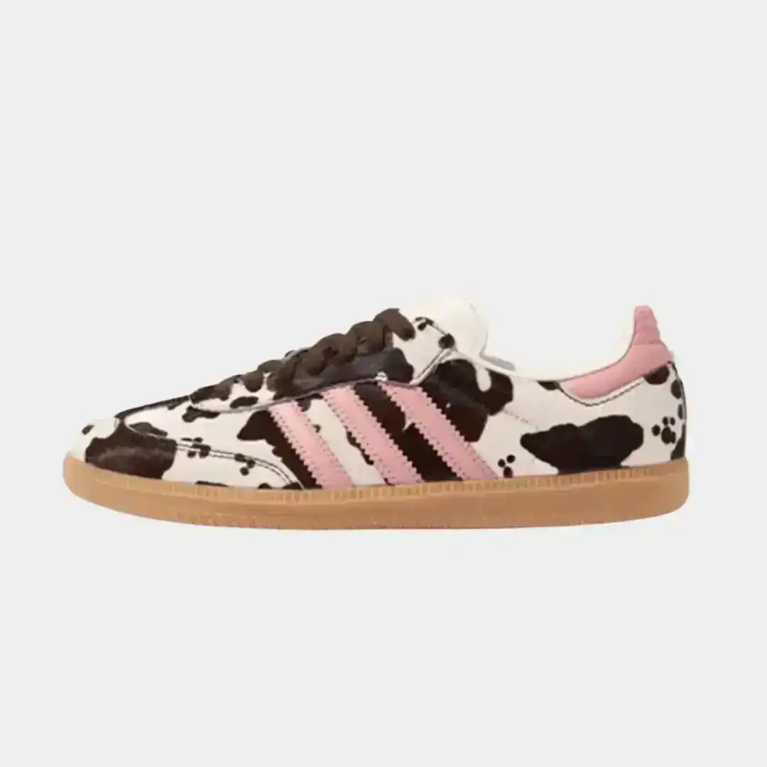 Adidas Samba OG Cow Print sneaker shown in side profile, featuring the iconic low-top Samba silhouette with animal-inspired patterned upper and classic gum outsole.
