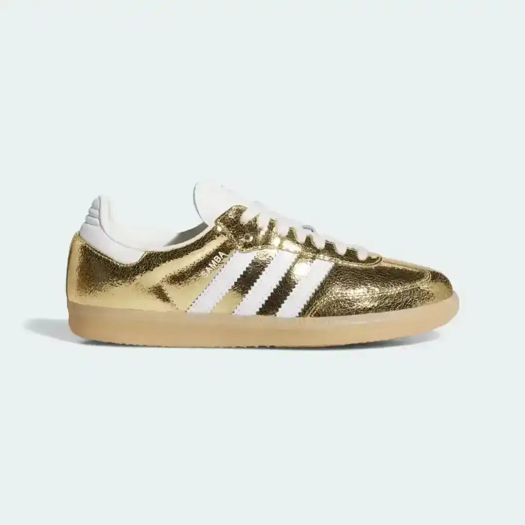 Gold-colored three-stripe low-top sneaker, side view.
