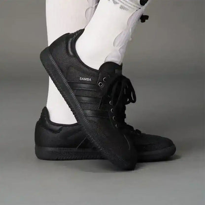 Aesthetic dark Adidas Samba sneakers featuring a deep black coarse surface, trending footwear choice for edgy fashion Pinterest boards.