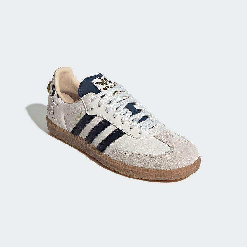 Cream three-stripe low-top sneakers with patterned heel details.
